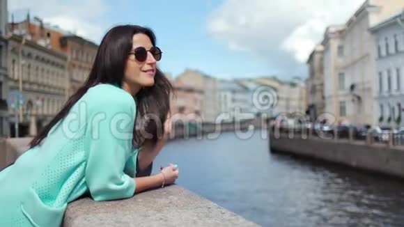 幸福优雅的旅游妇女欣赏着环绕城市的河流具有积极的情感视频的预览图