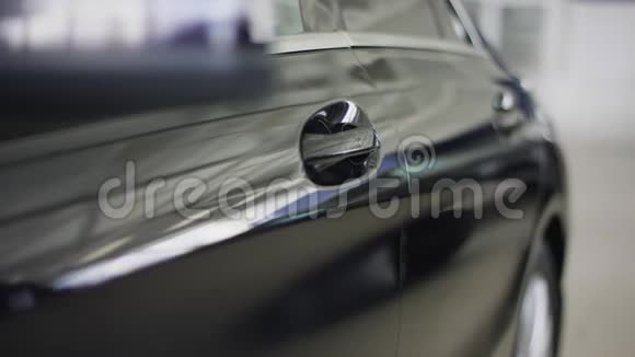 汽车经销店的人打开车门把手的特写车主坐在他的车里视频的预览图