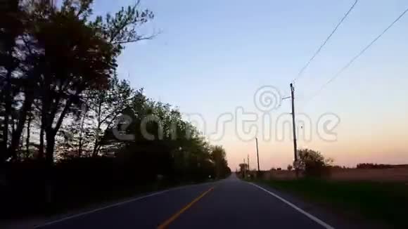 在夕阳西下逆向运动带动乡村道路的倒退司机的观点POV而太阳升起在何视频的预览图