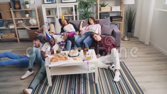 疲惫的男人和女人睡在沙发和地板上后愉快的聚会在公寓视频的预览图