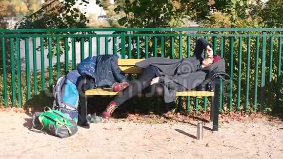 无家可归的美丽女孩躺在长凳上睡觉视频的预览图