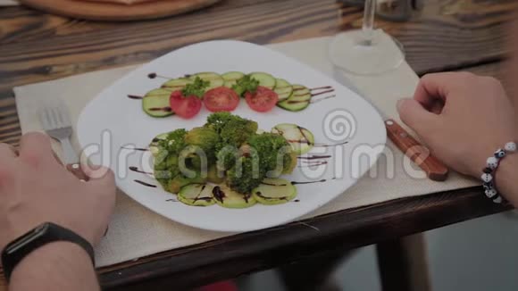 白色盘子里有沙拉男人手放在桌子上视频的预览图