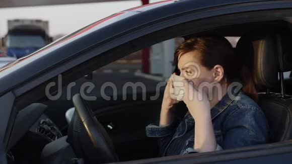年轻女子戴上医疗面具她开着一辆有孩子的车开车离开快关门冠状病毒主题视频的预览图