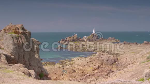 一条通往白色灯塔的岩石海滩路线视频的预览图