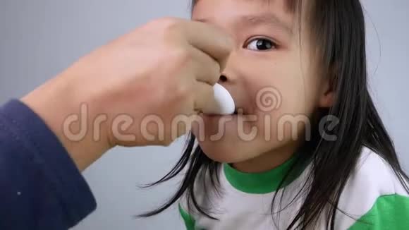 生病的小女孩吃药在卧室里用勺子止咳糖浆儿童保健和医疗的概念视频的预览图