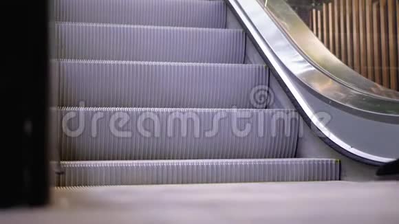 人们的腿在商场的自动扶梯电梯上移动购物中心扶梯上的购物者脚视频的预览图