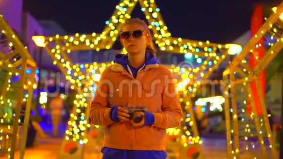 一个戴着胶卷相机眼镜的女孩站在城市环境中的一颗发光的星星旁边视频的预览图