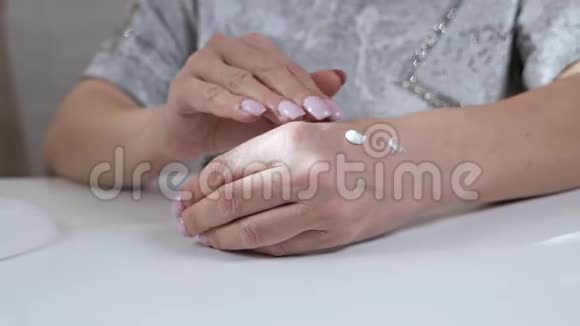 老年妇女把奶油放在手上这是一种家庭护肤的天然产品视频的预览图