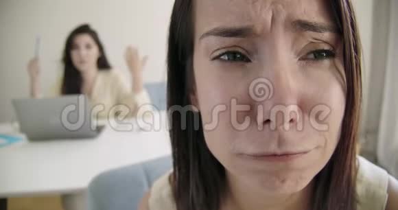 一个哭泣的白种人女孩的特写脸她的朋友或妹妹在背景上责备她小兄弟在争吵视频的预览图