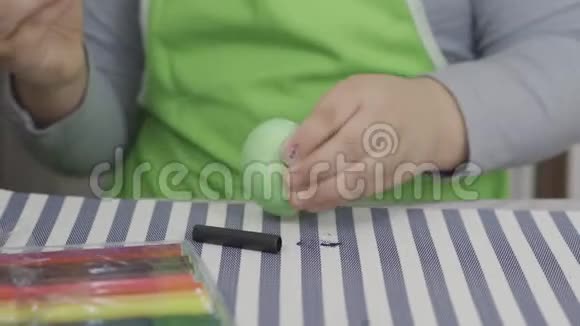 一个孩子玩一个鸡蛋然后打在桌子上准备复活节视频的预览图