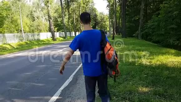 一个带背包的年轻人在路边搭车偷窥经济旅行视频的预览图