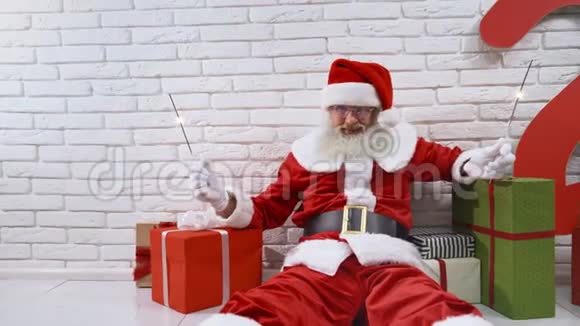 快乐的圣诞老人坐在地板上闪闪发光视频的预览图