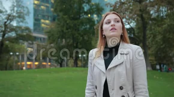 穿着时髦休闲服装的女性看着手腕上的手表城市公园晚上视频的预览图