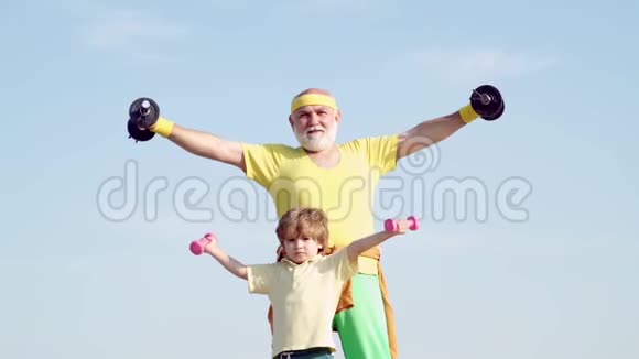 家庭健康俱乐部的老人和孩子父亲和儿子发现高级健身男子训练用蓝色哑铃视频的预览图