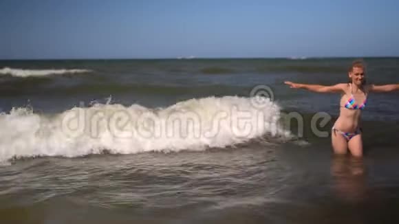 情感健康的女人在海滩上捕捉海浪比基尼美女视频的预览图