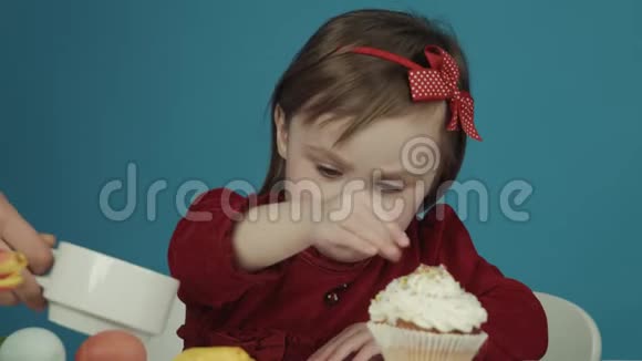 为复活节准备蛋糕的女孩撒上五颜六色的糖果复活节快乐视频的预览图