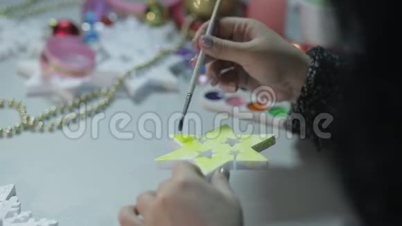 女人用水彩画白色的空白为圣诞节做家居装饰视频的预览图