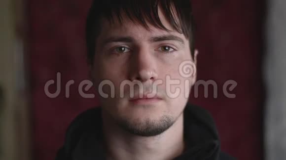 特写一幅年轻男性的情感肖像在镜头前眨眼视频的预览图