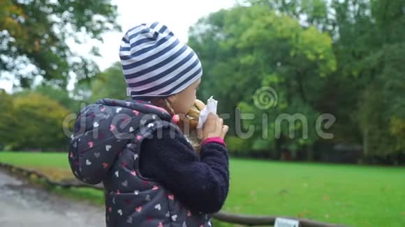 公园里吃汉堡的小女孩视频的预览图