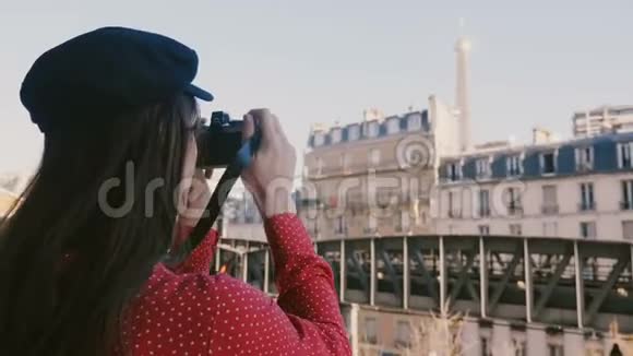 快乐的职业摄影师穿着红色连衣裙用老式相机拍摄巴黎埃菲尔铁塔景色的照片视频的预览图