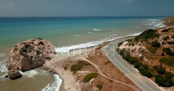 在塞浦路斯帕福斯地中海海滩和海岸附近的一条公路上飞行的鸟瞰图视频的预览图