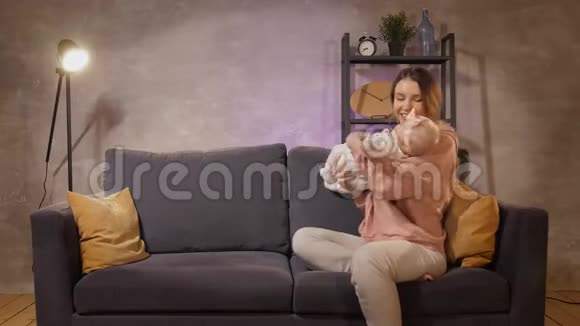 一个年轻的家庭坐在沙发上一起玩妈妈爸爸和女儿都很开心那人送给妻子一份礼物视频的预览图