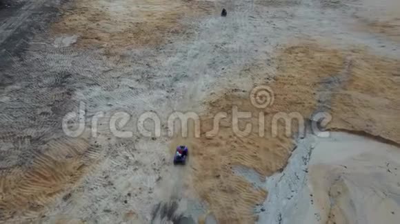 在乡村乘坐ATV的人的空中视野鸟在地面上极端驾驶的视野视频的预览图