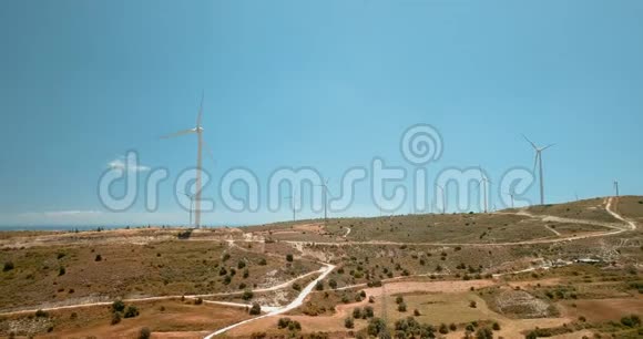绕着塞浦路斯生态发电厂的大型风力涡轮机飞行对车站巨大建筑的无人视野视频的预览图