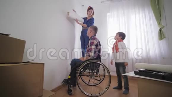 亲爱的丈夫坐轮椅的残疾人和他友好的家庭为修理室选择新的壁纸视频的预览图