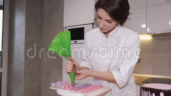 一个微笑的女人面包师正在做马卡龙视频的预览图