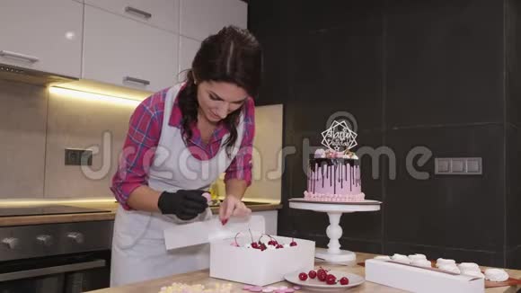 女面包师正在用樱桃装饰自制的纸杯蛋糕视频的预览图