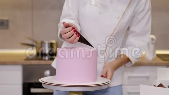 女糖果师正在用融化的巧克力装饰生日蛋糕视频的预览图