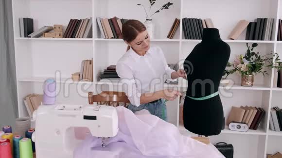 漂亮的女裁缝用胶带测量衣服的形状视频的预览图
