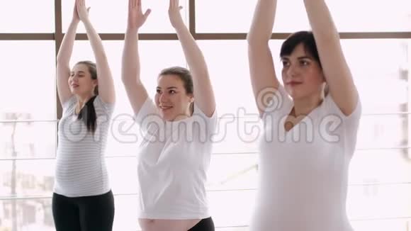 在现代健身房里和教练一起做伸展运动的女人视频的预览图