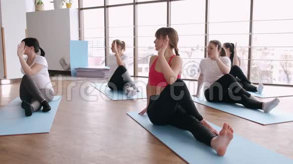 女人在健身房里和健身教练一起伸展身体视频的预览图