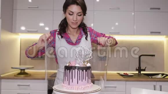 女厨师正在用透明的盒子里用胶带包装生日蛋糕视频的预览图