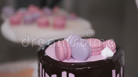 女面包师正在装饰一个生日蛋糕与马克龙在顶部视频的预览图