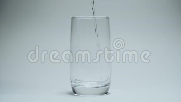 清澈的饮用水倒入白色背景上干净的透明玻璃中视频的预览图