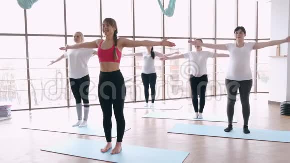 在现代健身房里和教练一起做伸展运动的女人视频的预览图