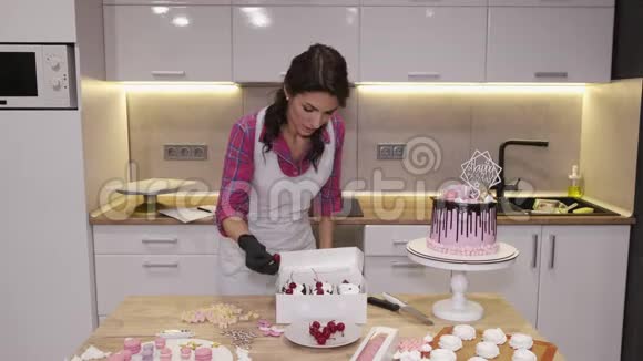 女面包师正在用樱桃装饰自制的纸杯蛋糕视频的预览图