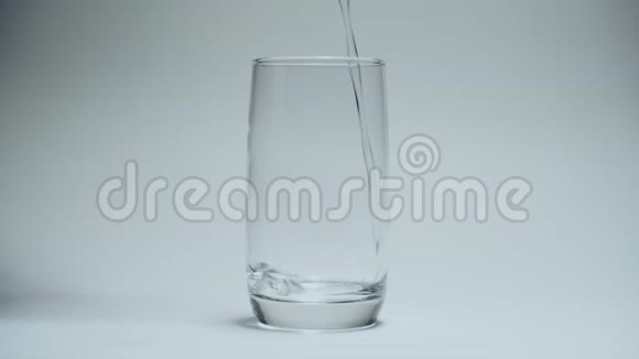 清澈的饮用水倒入白色背景上干净的透明玻璃中视频的预览图