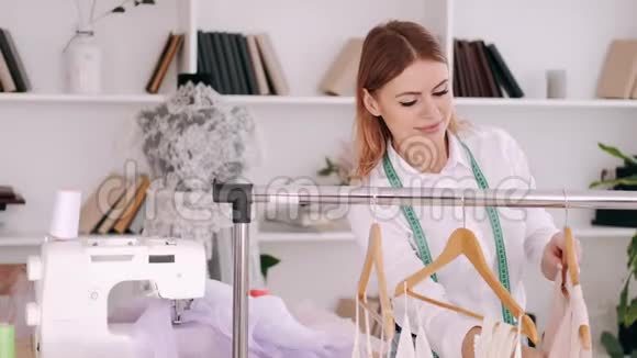 一位女裁缝正在欣赏衣架上的一件衣服视频的预览图
