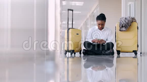 带着手提箱的女人坐在机场大厅里自拍视频的预览图