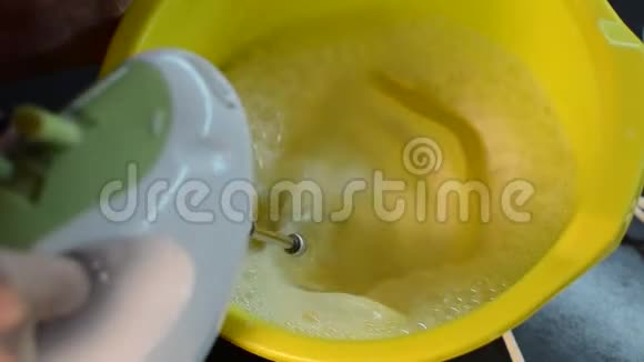 电动搅拌器将面团搅拌在盘子里视频的预览图