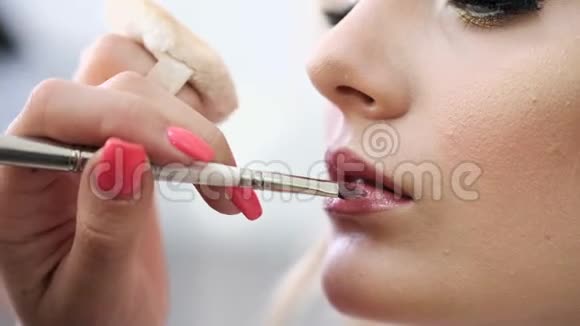 化妆师将化妆品涂在女人嘴唇上视频的预览图
