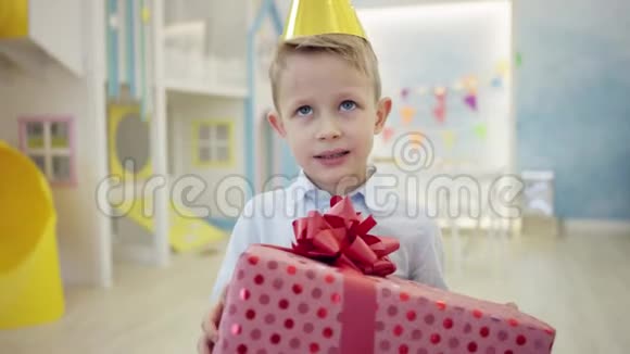 不高兴的男孩拿着生日礼物在镜头前视频的预览图