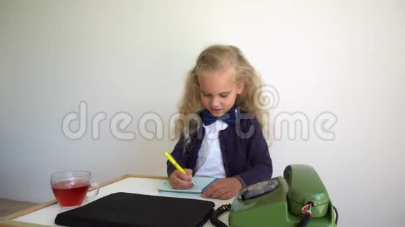 可爱的女孩坐在桌子旁带着复古的电话儿童游戏秘书万向节运动视频的预览图