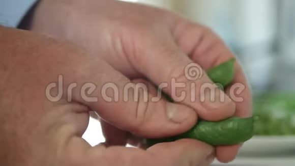 男人在厨房的活动选择和清洁新鲜的绿色豌豆烹饪视频的预览图