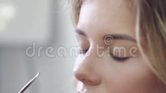 在化妆的过程中年轻女子的面部特写视频的预览图