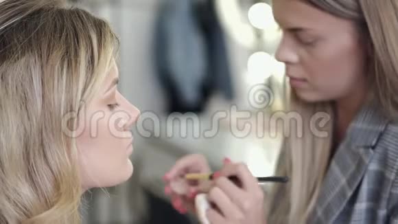 化妆师将化妆品应用于客户沙龙的面部视频的预览图